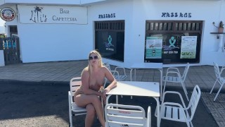 Chica sentada desnuda en un café en público.