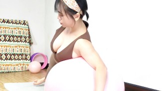 Big-breasted beauty with hairpins performs fitness exercises on a yoga ball