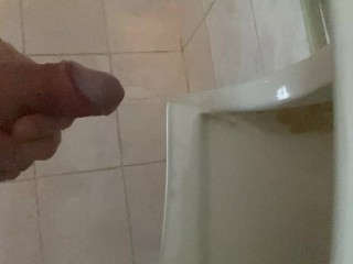 Pissing with a big dick with big balls in a public toilet in a urinal
