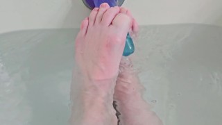 Cute Pink dedos de los pies jugando con un consolador en el baño