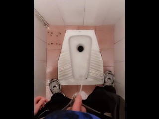 公衆トイレで放尿する若い男