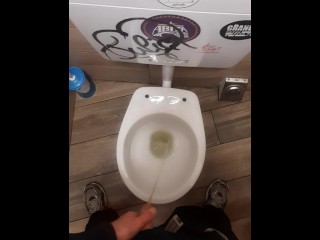Young Man Pissing in a Bar Toilette