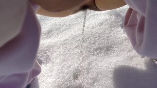A Japanese woman pees in the snow outdoors.