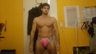 Chico flaco desnudándose en tanga rosa