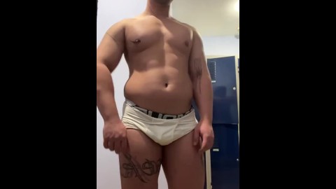 Chico chub muestra su cuerpo musc después del gimnasio en calzoncillos debajo de la armadura