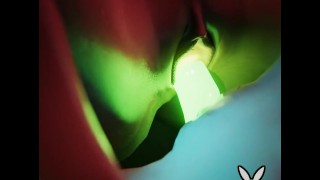 緑の輝くダブルエンドディルドを使用して電池を充電する途中の2人のレズビアン