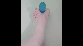 Consolador azul entre mi Cute pequeños dedos de los pies pintados en el baño
