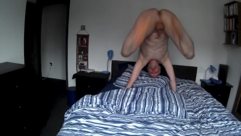Naked man bouncing on the bed