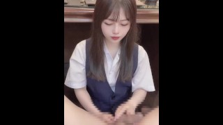 Japanese girl wearing catsuit gives a guy a handjob while rubbing her boobs.