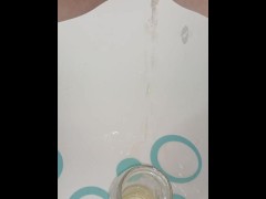 Creamy pussy pisses at a drinking glass