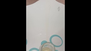 Creamy pussy pisses at a drinking glass