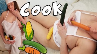 Chubby blonde cook inserting cucumber, carrot and corn