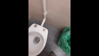 Un jeune chav pisse dans les toilettes publiques