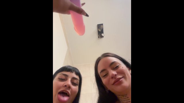 Two hot brunettes suck a dildo