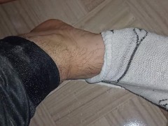 Man comes home from work and the first thing he does is to massage his feet.