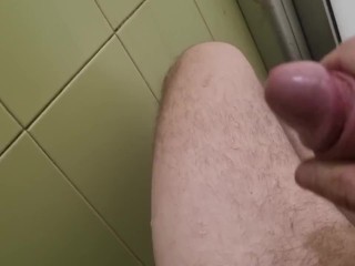 Um Cara com Um Pau Grande Se Masturba Em Um Banheiro Público e Goza Na Parede