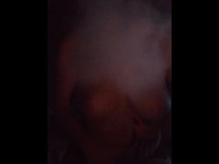 girl with nipple piercing smokes in a balaclava