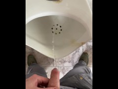 A man peeing in a public toilet, POV