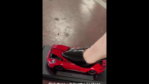garota sexy esmaga brinquedos de carro com saltos altos