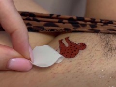 Tattoo master in leopard panty doing temporary tattoo