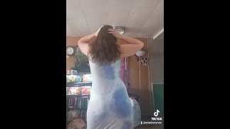 Фигуристая красотка в маске в обтягивающем платье танцует для папы и друзей, тряся большой