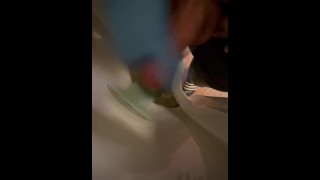 Masturbandose en el urinario con guantes de nitrilo azul