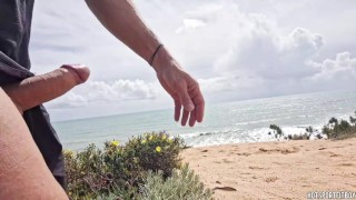 Mooie fitnessman trekt zich af op een openbaar strand - riskant en bijna betrapt