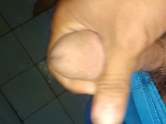 young man plays with his genitals in the bathroom