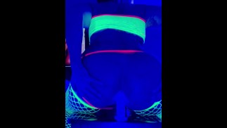 Sissy cross dresser twerks and plays with anal toys in neon Blacklight while watching porn