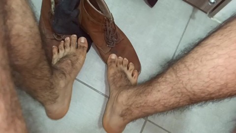 男性的脚。看着这个伐木工人的脚和毛茸茸的腿。舔它还是闻它？