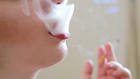 Naked getatoeëerd model rookt Camel s100 sigaret