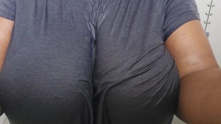 Peitos grandes e mamilos gordos em camisa T molhada