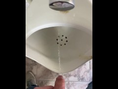 Guy pees in a public toilet POV