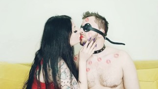 Fetiche de besos. Dominatrix besa a su amado esclavo y le deja marcas de lápiz labial en el cuerpo