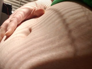 Пухлый Энби играет с большим животом на солнце