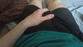 A guy in shorts erotically strokes his groin