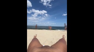 figa pubblica lampeggiante sulla spiaggia per nudisti allargando le gambe aperte quando la gente passa