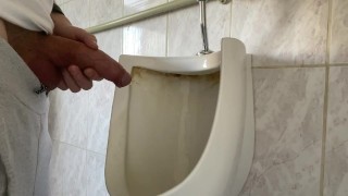 男人在公共厕所里用未切割的大鸡巴撒尿