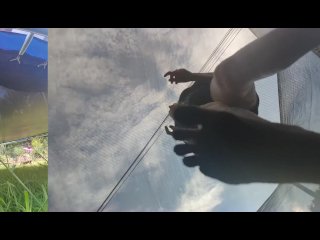 Tall girl in shorts jumping barefooted on a trampoline (slowed down) bottom view