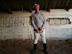 The farmer in rubber boots pees in his white pants and plays with his cock in the barn
