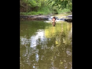 Девушка выставляет напоказ грудь под водопадом