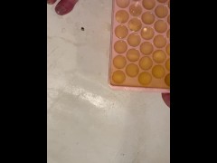 Girl fills ice cube tray with piss