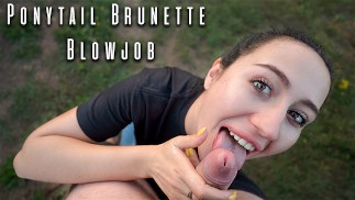 Une brune à queue de cheval suce une bite en extérieur