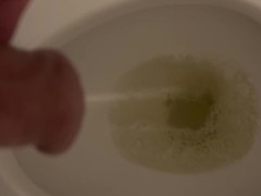 Guy takes a piss in the toilet