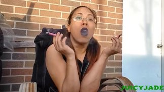 Goth Asian in leather smoking multiple cigarettes at once