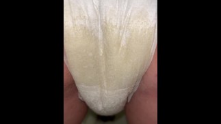 Girl pisses in diaper close up from behind