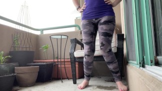 girl wetting grey leggings outside on the balcony