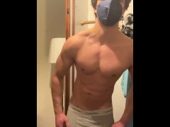 Young bodybuilder flexing muscles and stripping down