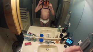 Chiot garçon dans une couche dans la baignoire pour jouer avec sa pompe à pénis et son gode