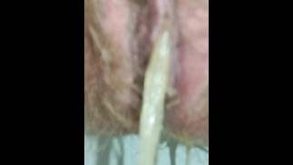 Hairy MILF in white bodysuit pissing close up